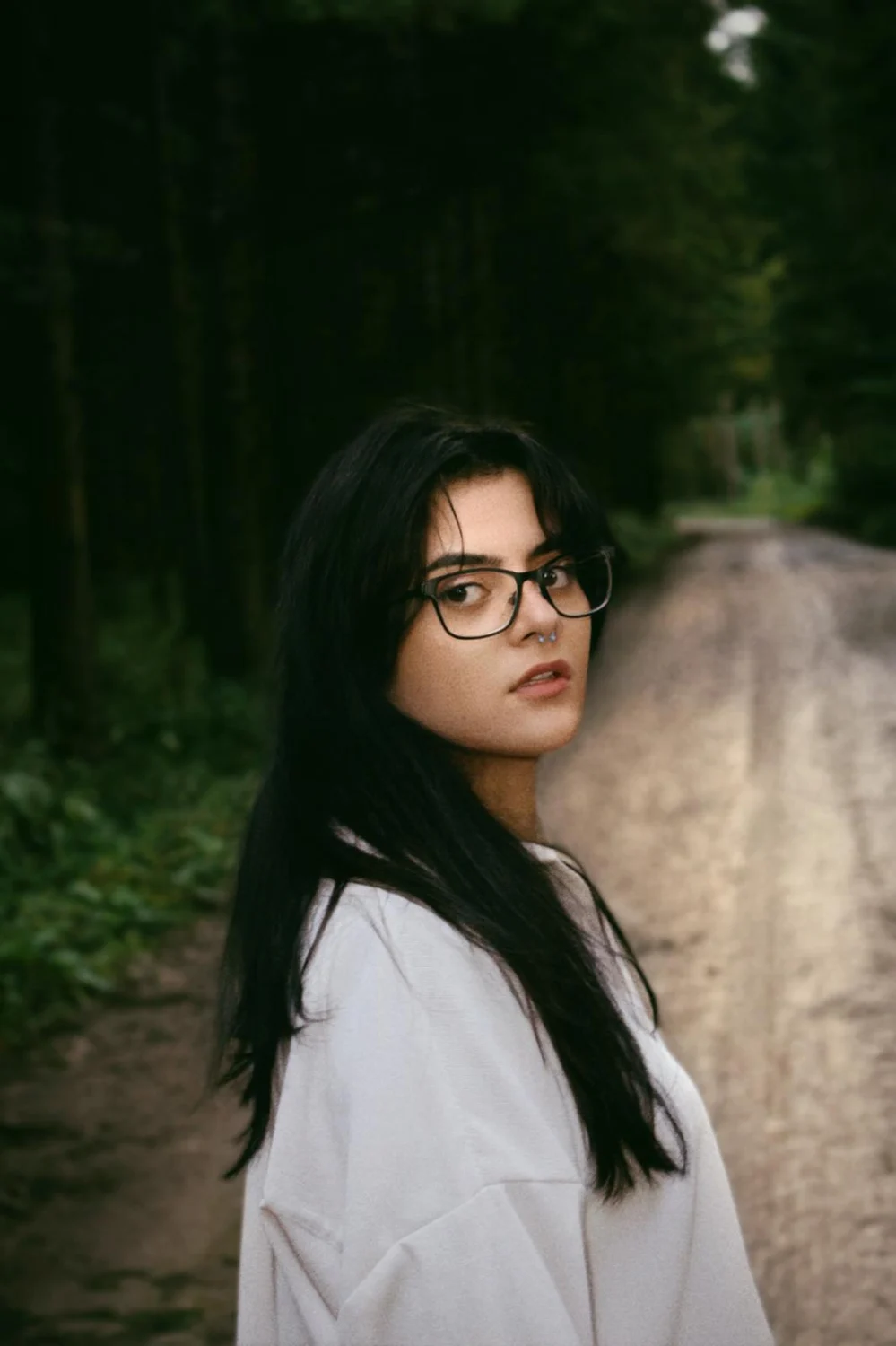 Andreea looking back on a woodland path