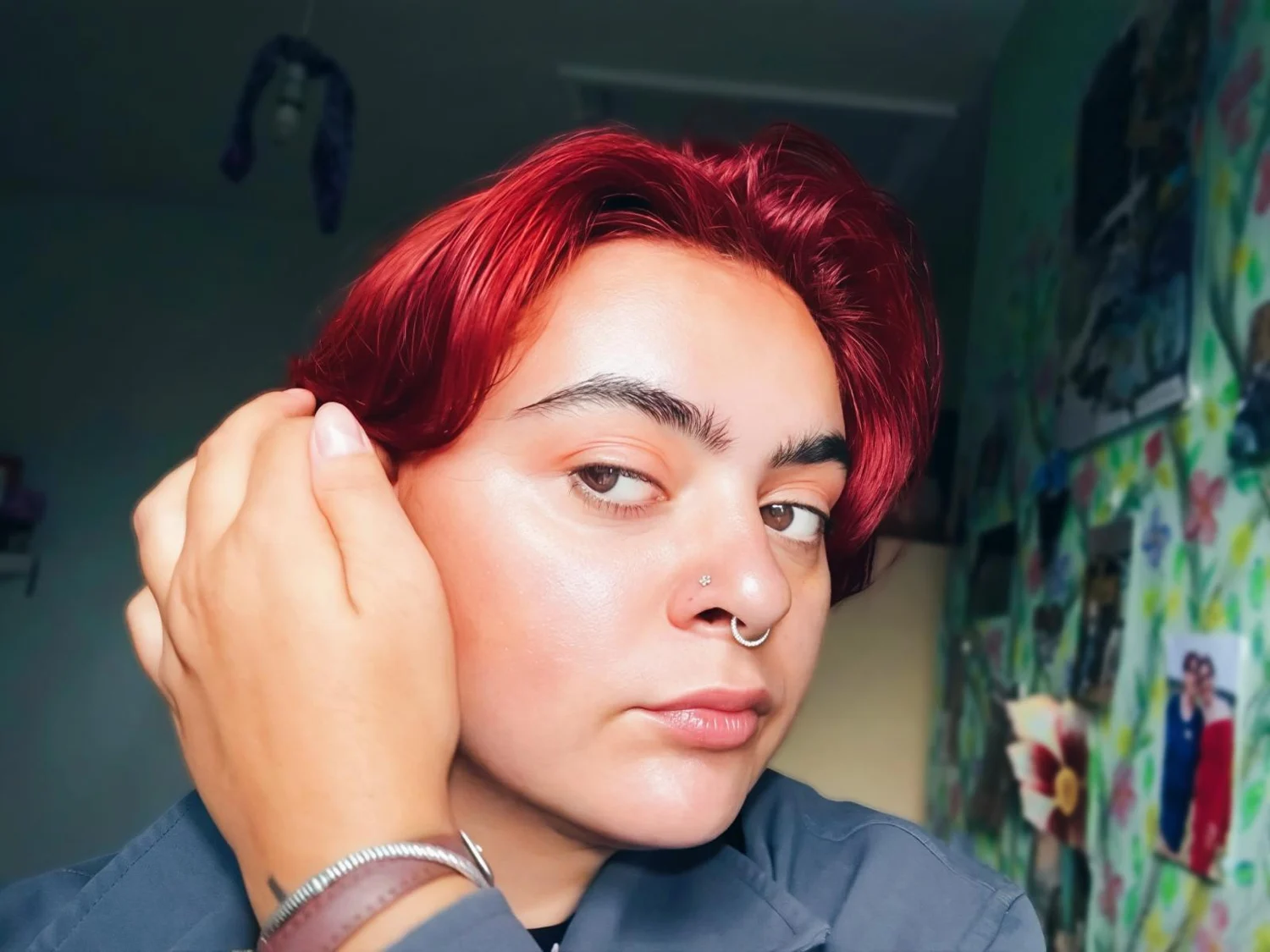 Andreea with red hair, her hand tucked beside her ear